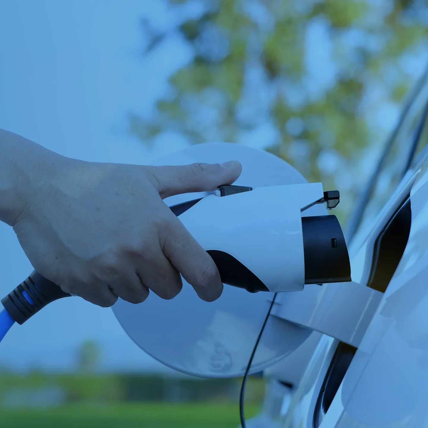 Driver connecting an electric vehicle charging cable