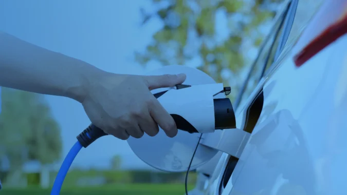 Driver connecting an electric vehicle charging cable