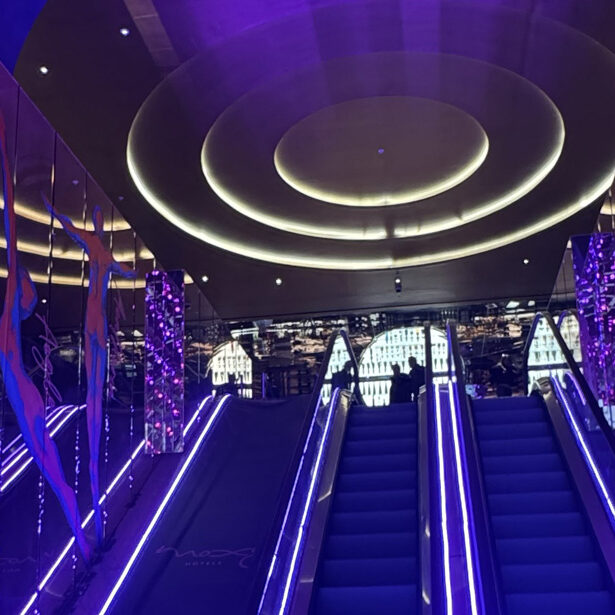 Purple-lit escalators and circular ceiling lighting at Moxy London Piccadilly Circus