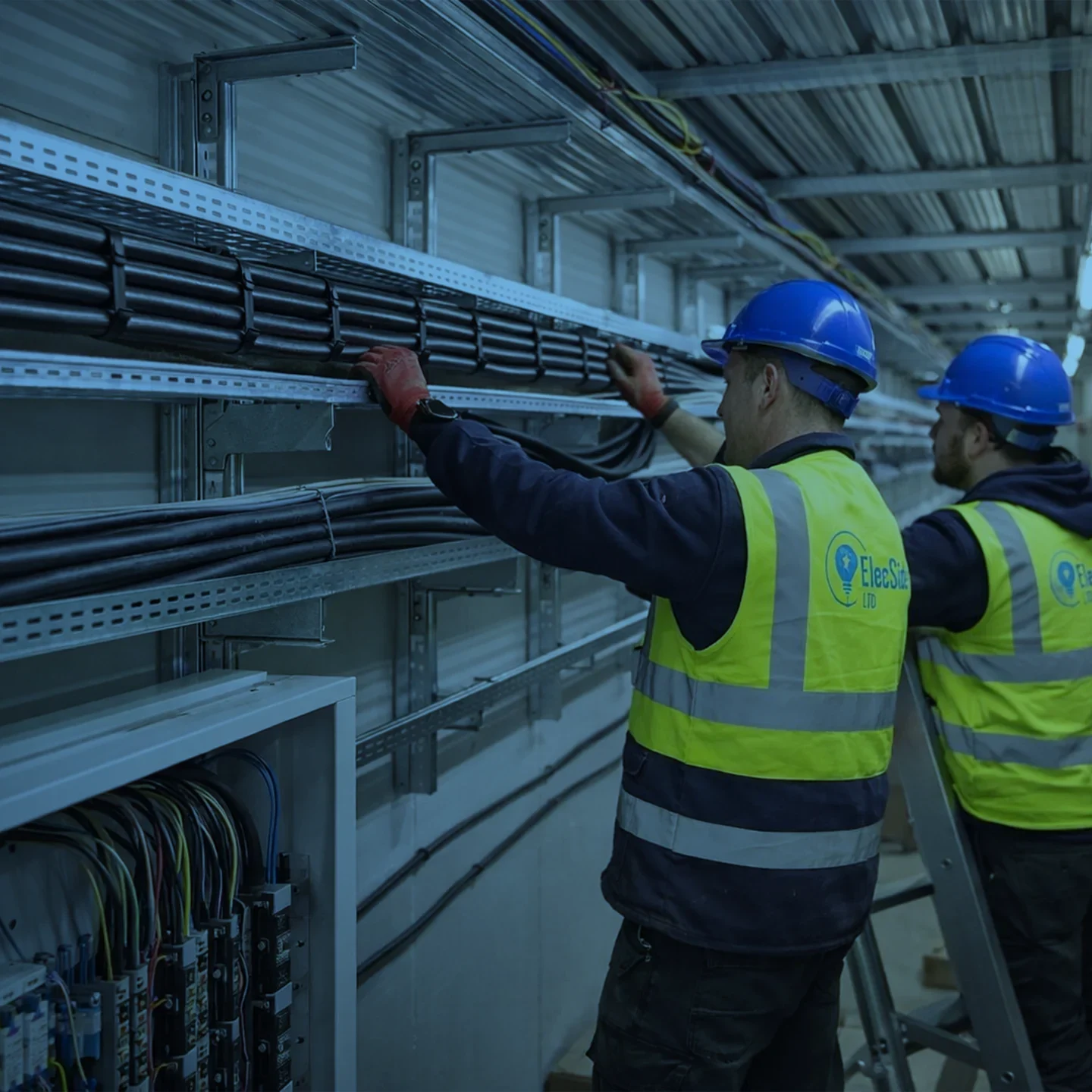 Electricians installing cable containment in a commercial building