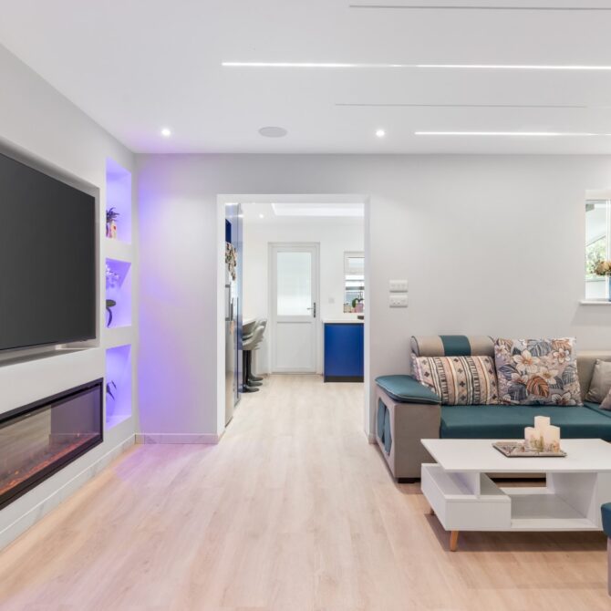 Living room at 6 Peters Avenue with recessed ceiling lights and illuminated shelving